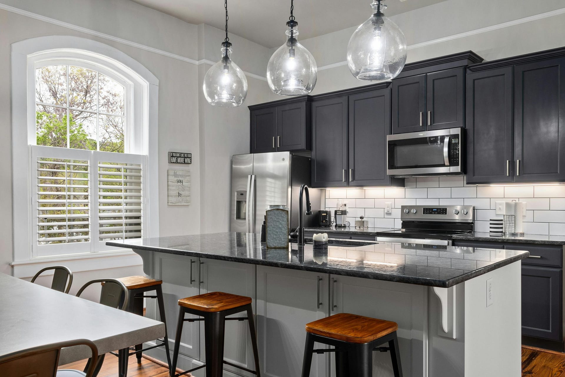 shaker kitchen in two tone grey and a breakfast bar with dark coloured stools