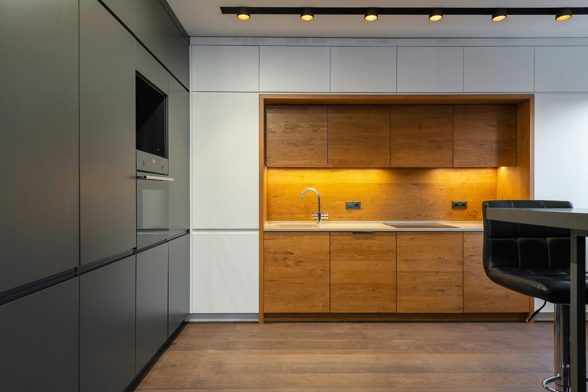 modern handleless kitchen with mood lighting and a wooden floor
