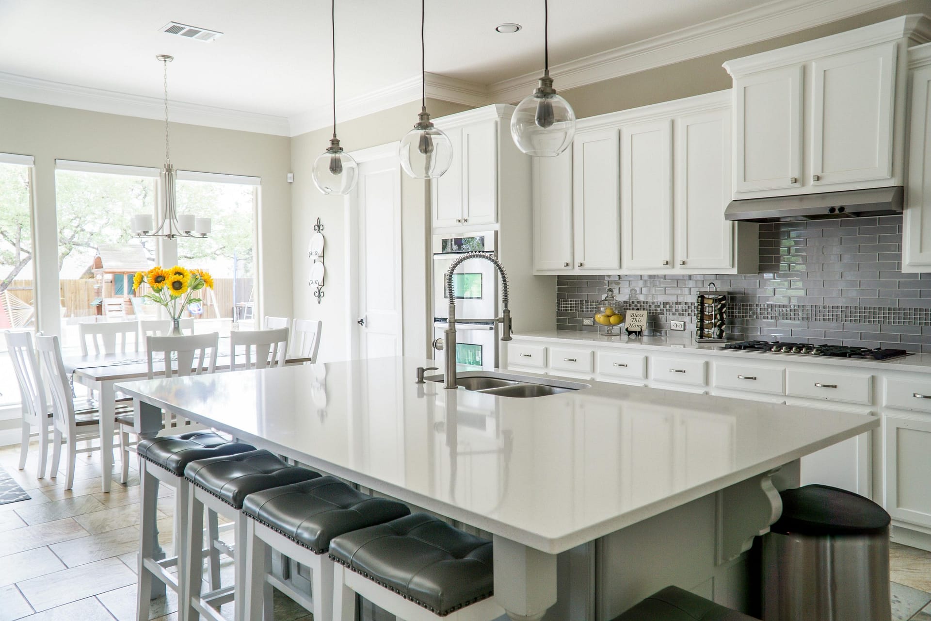 a kitchen with white cabinets and a large island