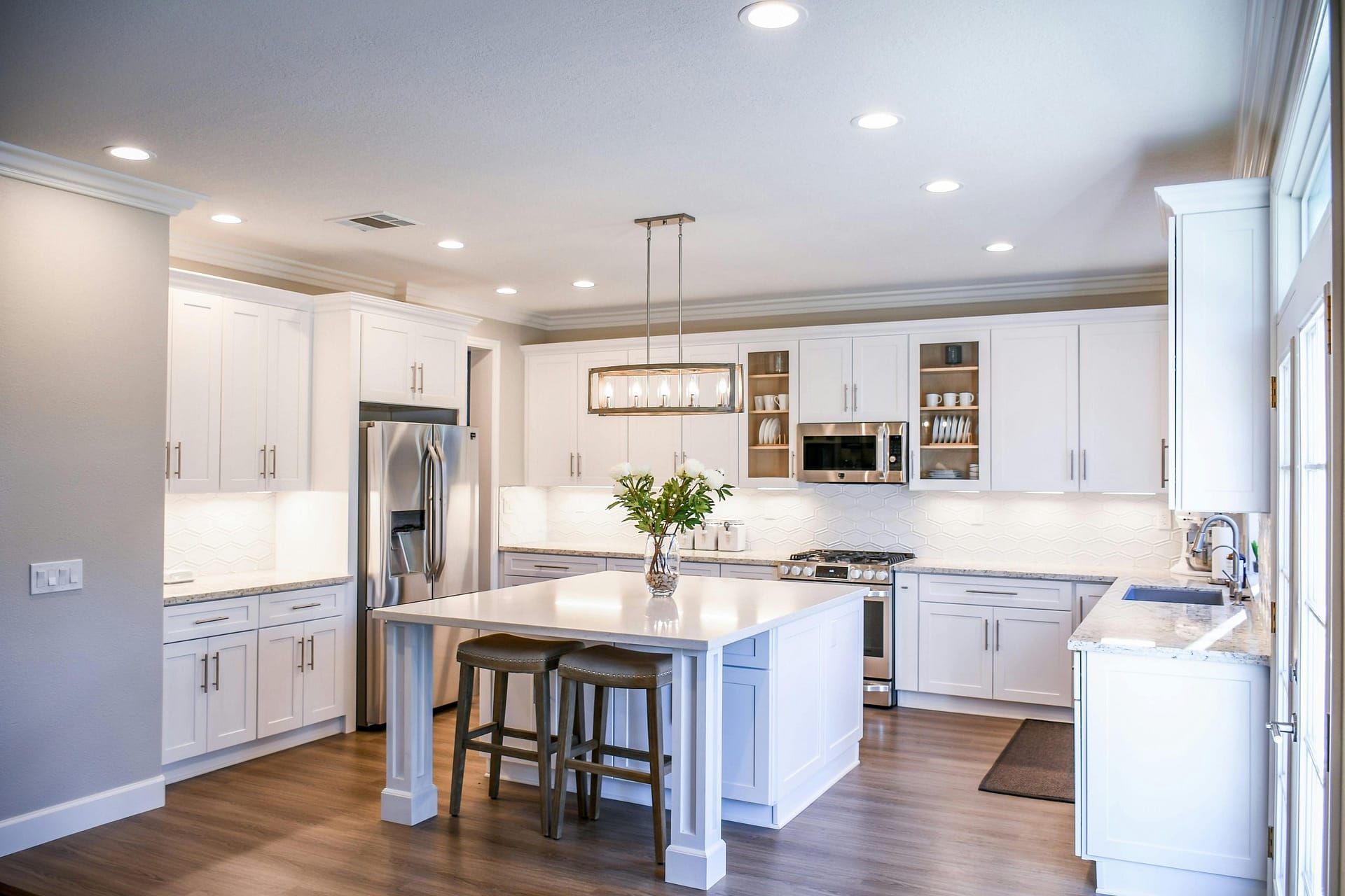 a kitchen with white cabinets and a table